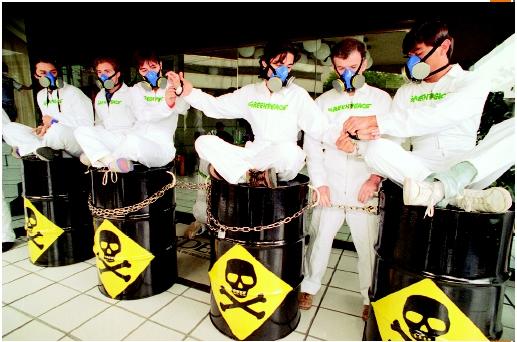 Greenpeace members handcuffed together and sitting on steel drums similar to toxic waste drums outside of the Mexican Office of Environmental Protection, calling attention to the toxic waste disposal facility at Guadalcazar, San Luis Potosi, owned by the U.S. company Metalclad Corporation, Mexico City, Mexico, July 19, 1995. (AP/Wide World Photos. Reproduced by permission.)