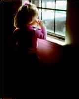 A little girl is standing and gazing out a window. Dust settling in windows may contain lead, a result of the use of lead-based paint in homes. (©2003, Robert J. Huffman, Field Mark Publications. Reproduced by permission.)